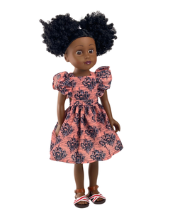 Poupée noire aux cheveux afro, robe en wax rose et bleu marine, vue de face